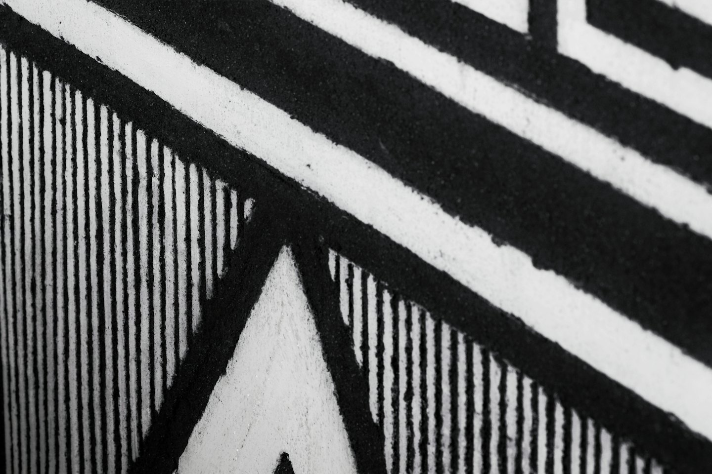 Geometric pattern of bold black lines and white stripes.